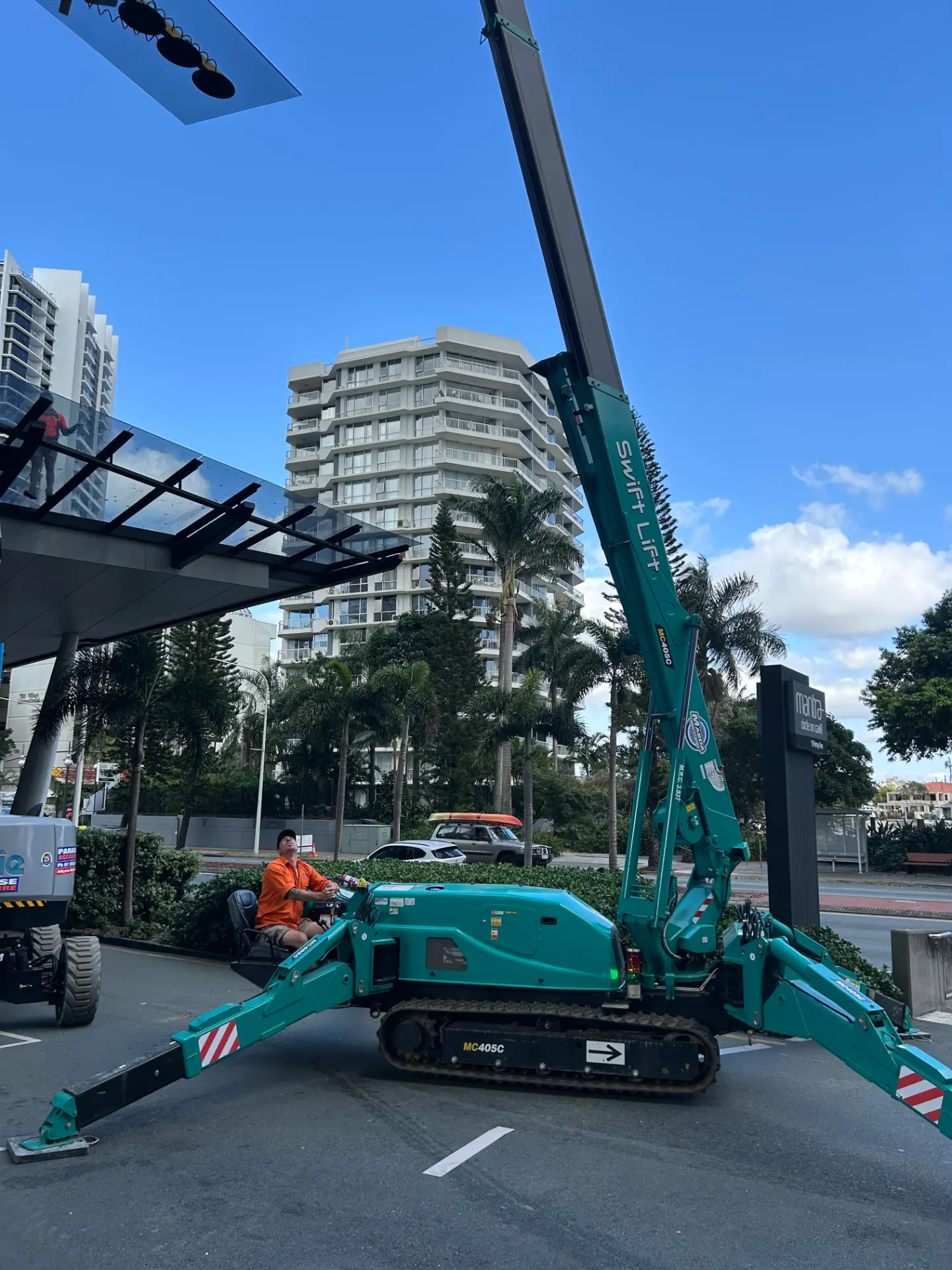 Crane positioned for commercial glass lifting beside a building on the Gold Coast