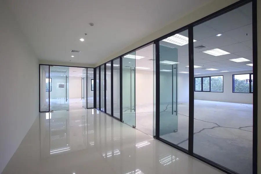 Bright empty office corridor with glass partition walls