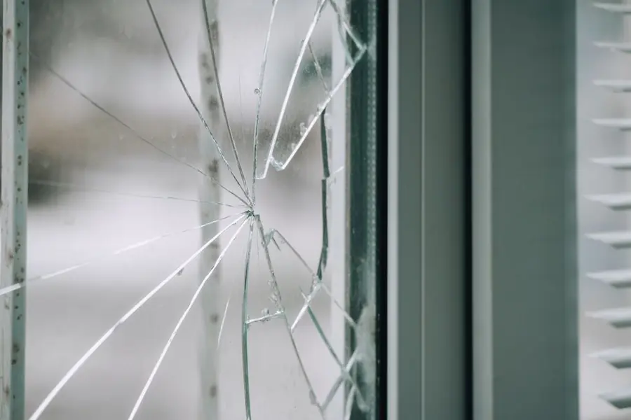 Close-up of a cracked glass window with a spiderweb pattern