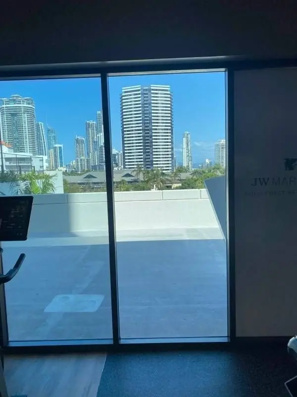 Glass balcony door overlooking a Gold Coast high-rise cityscape