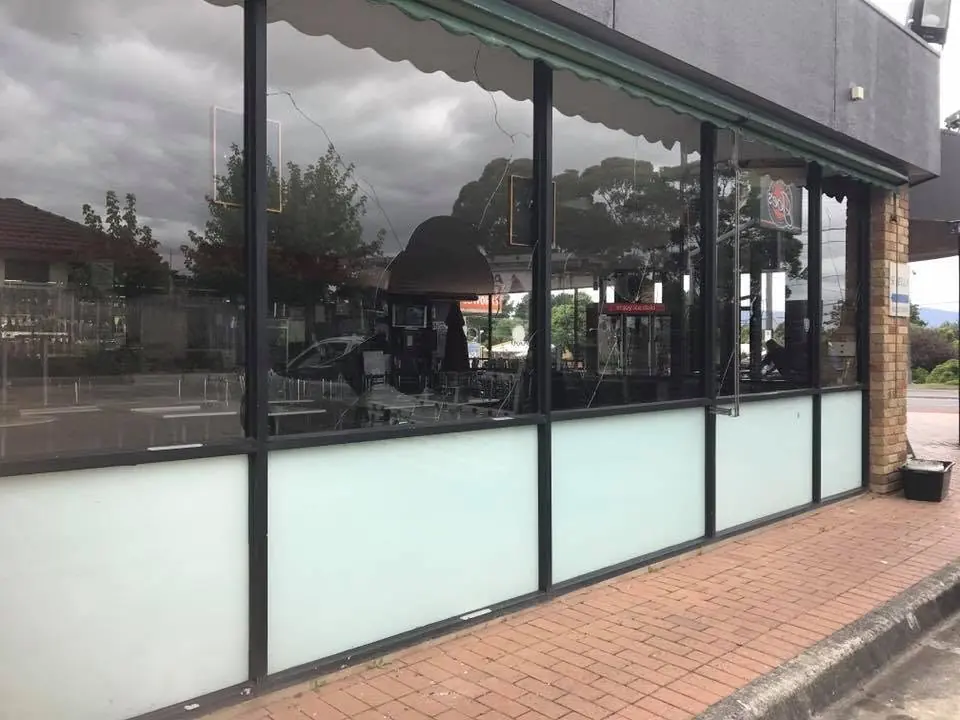 Glass-fronted commercial shopfront with black window frames and frosted lower panels