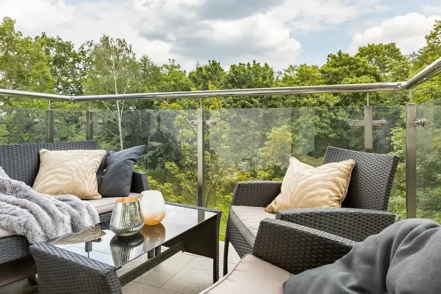 Outdoor lounge balcony with glass railing at a modern home