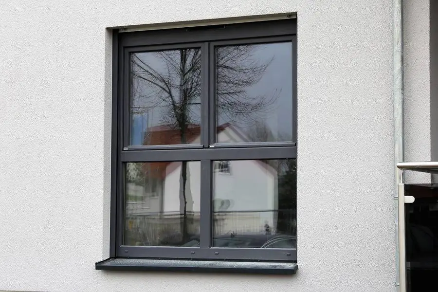 Clean aluminium-framed window with tempered glass on a house exterior