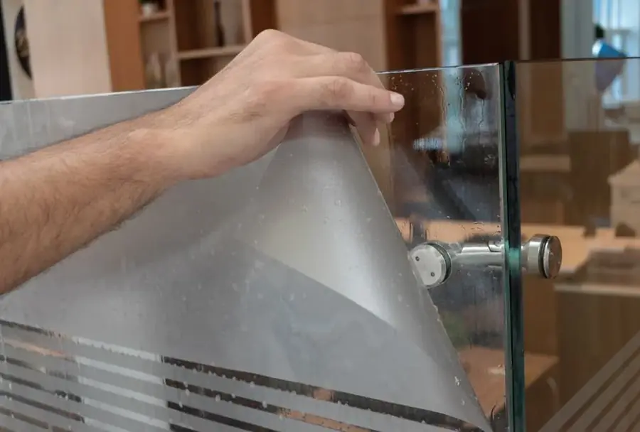 Hand using a suction lifter tool on a window pane
