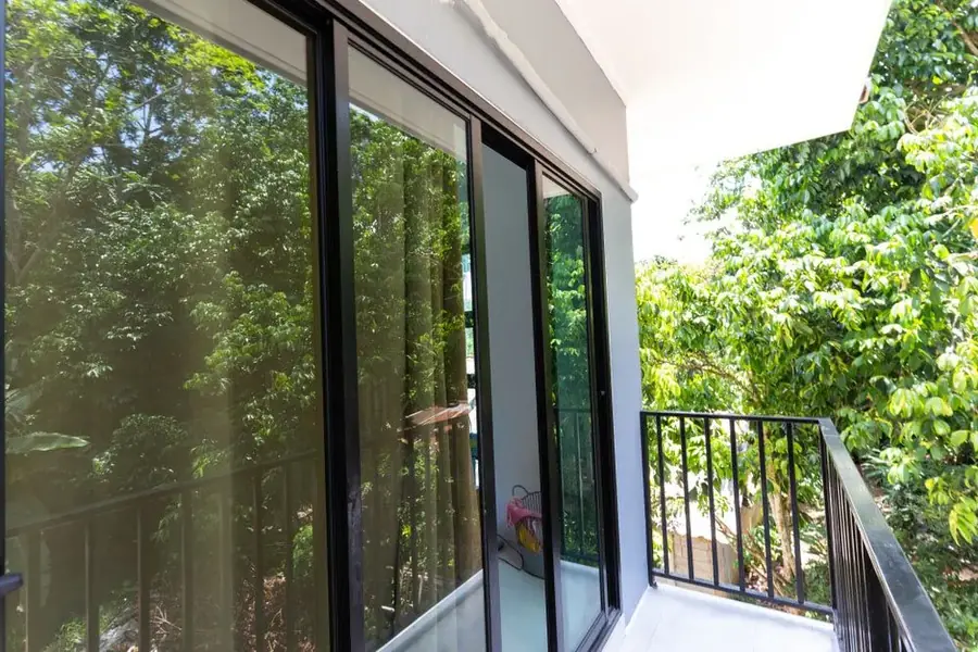 Balcony sliding glass doors framed by surrounding trees