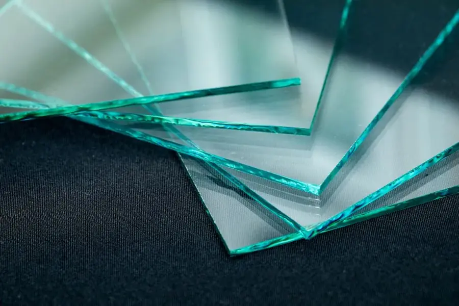 Stack of cut glass sheets photographed against a dark background