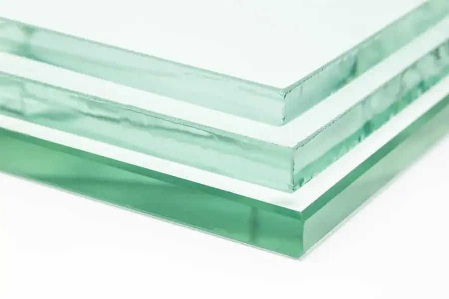 Edge view of stacked laminated glass sheets showing a green tint