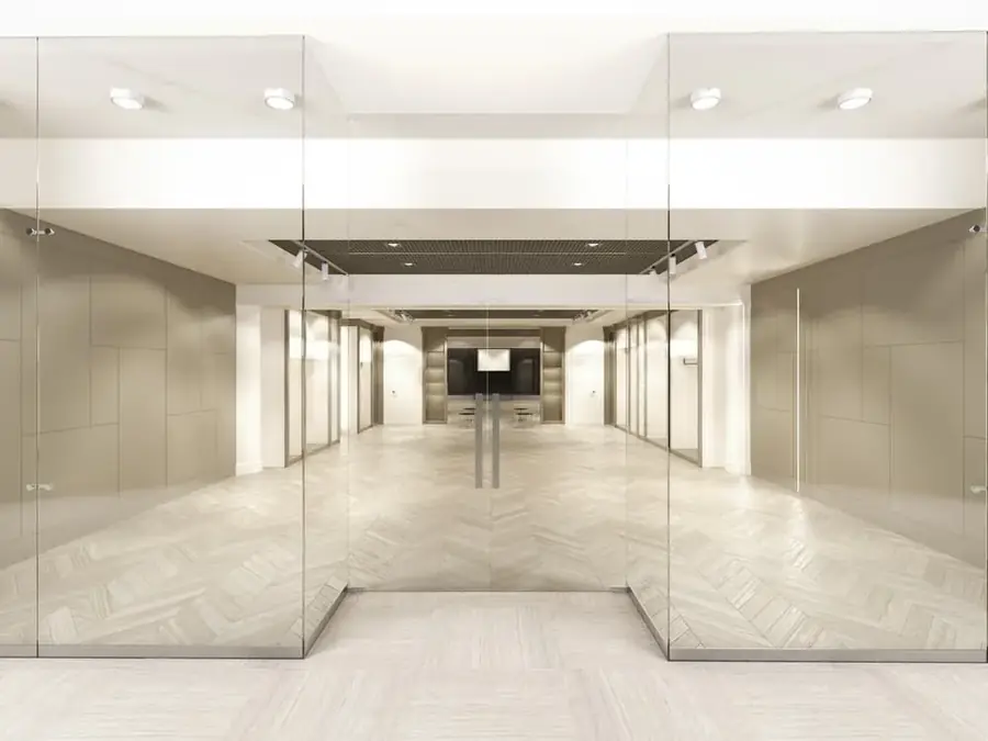 Bright glazed commercial lobby corridor with polished flooring