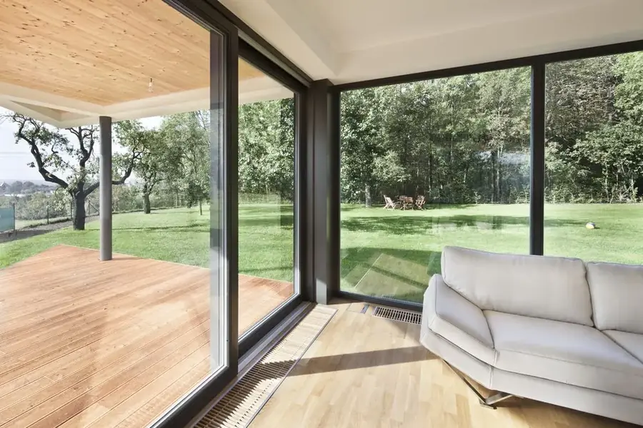 Living room with floor-to-ceiling glass doors opening onto a golf course view